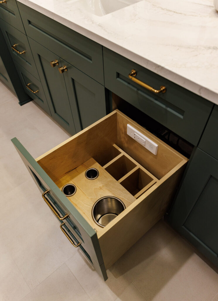 A completed bathroom remodel with A hot tools drawer in a vanity pulled out to display innovative storage, and electrical connections built into the drawer.